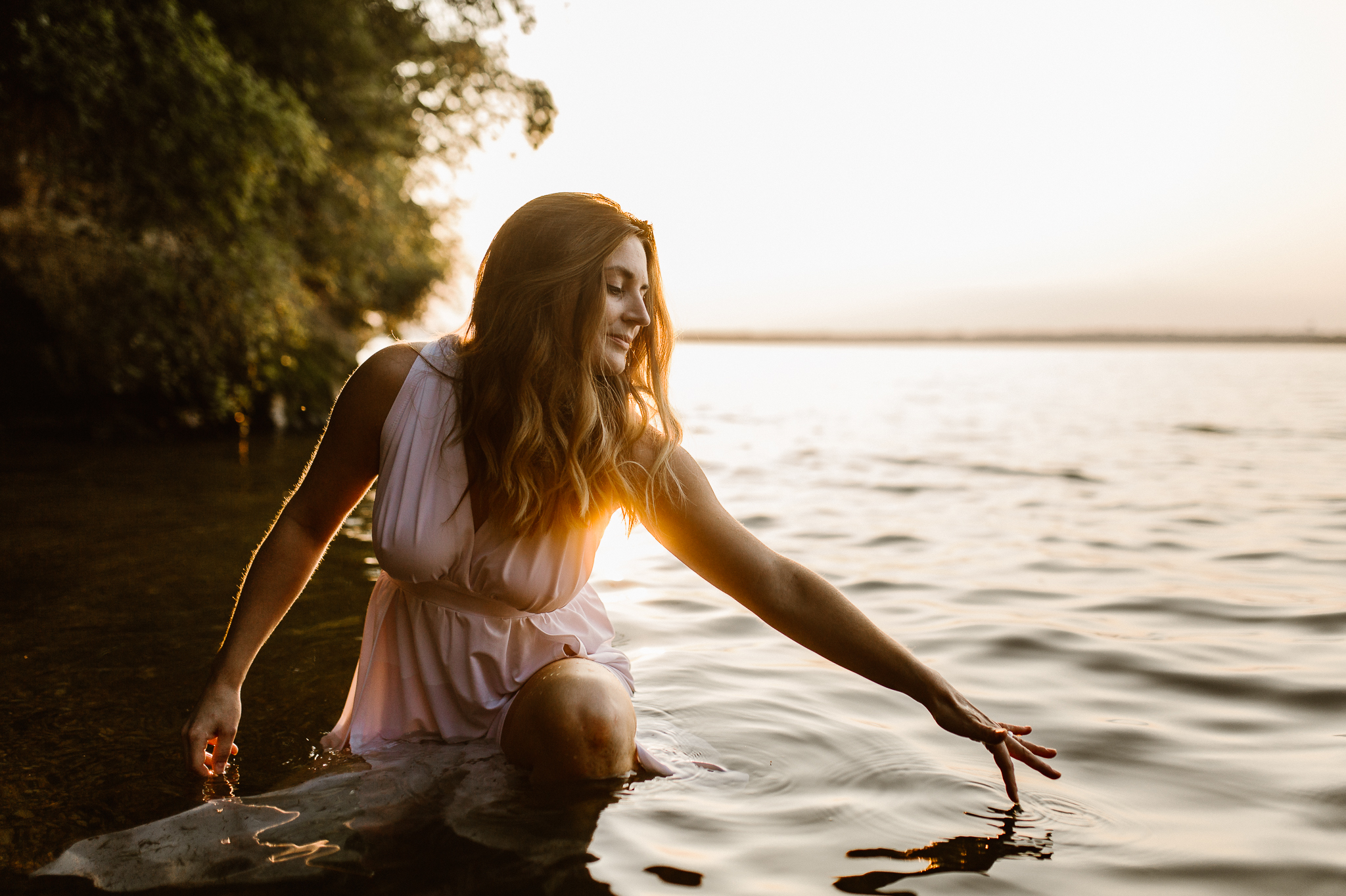 Captivating woman in an intimate lake session during a summer sunset.
